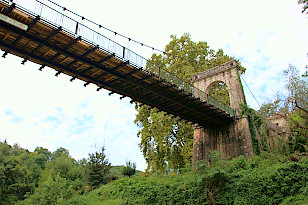 Hängebrücke mit Holzplanken vor der Bastide Vianne